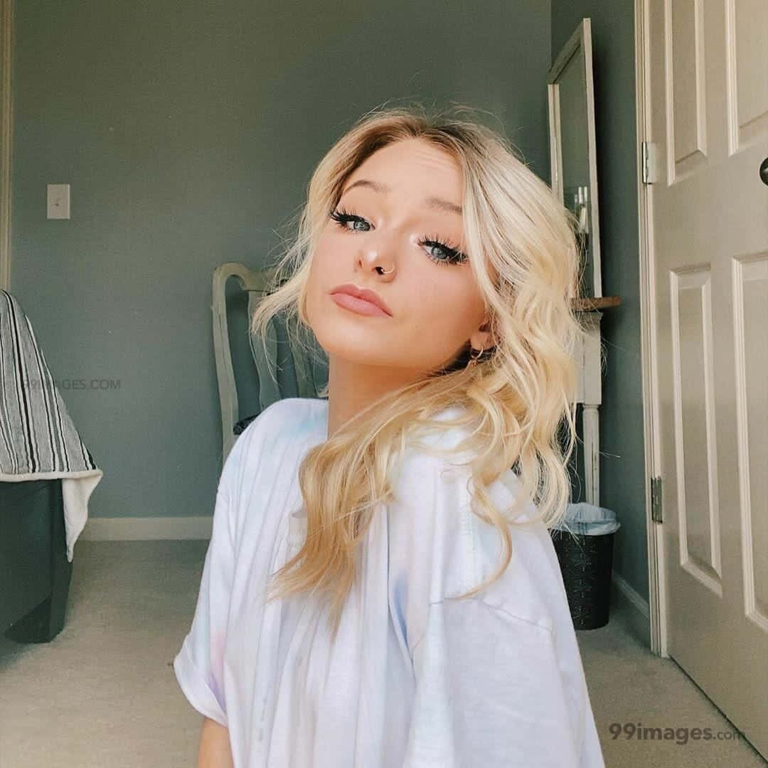 A Blonde Girl With Long Hair Posing In A Room Wallpaper