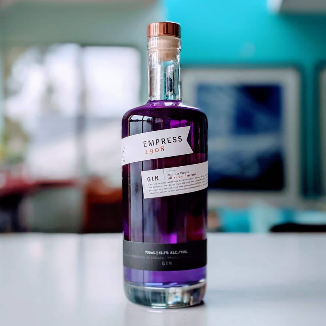 A Bottle Of Empress 1908 Gin Presented On A Sleek, Modern Table. Wallpaper