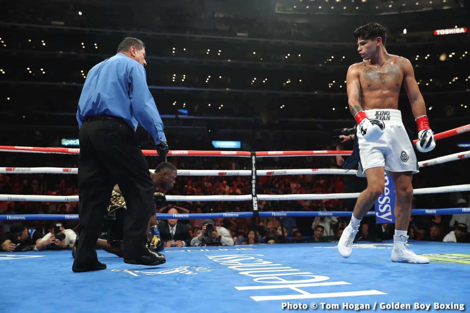 A Boxer Is Standing On The Ring With A Referee Wallpaper