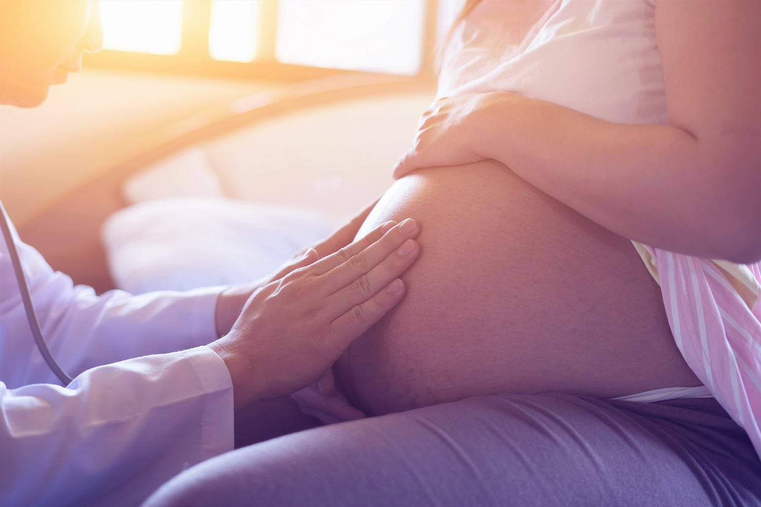 A Caring Doctor Massaging A Pregnant Belly Wallpaper