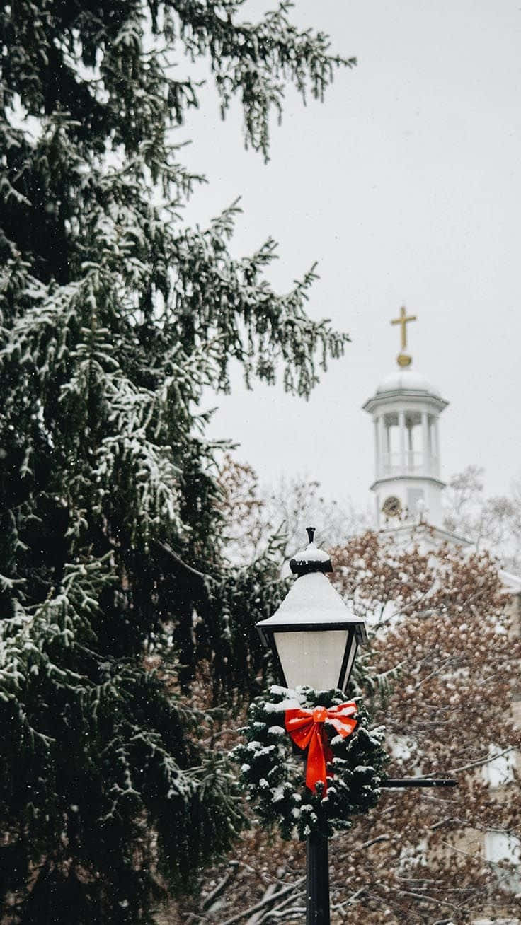 A Christmas Tree And A Street Light In The Snow Wallpaper