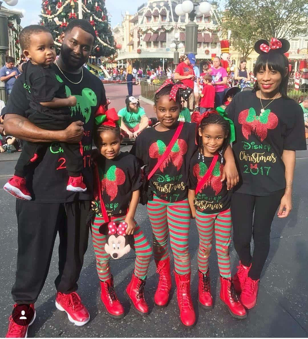 A Family Posing For A Photo In Front Of A Christmas Tree Wallpaper