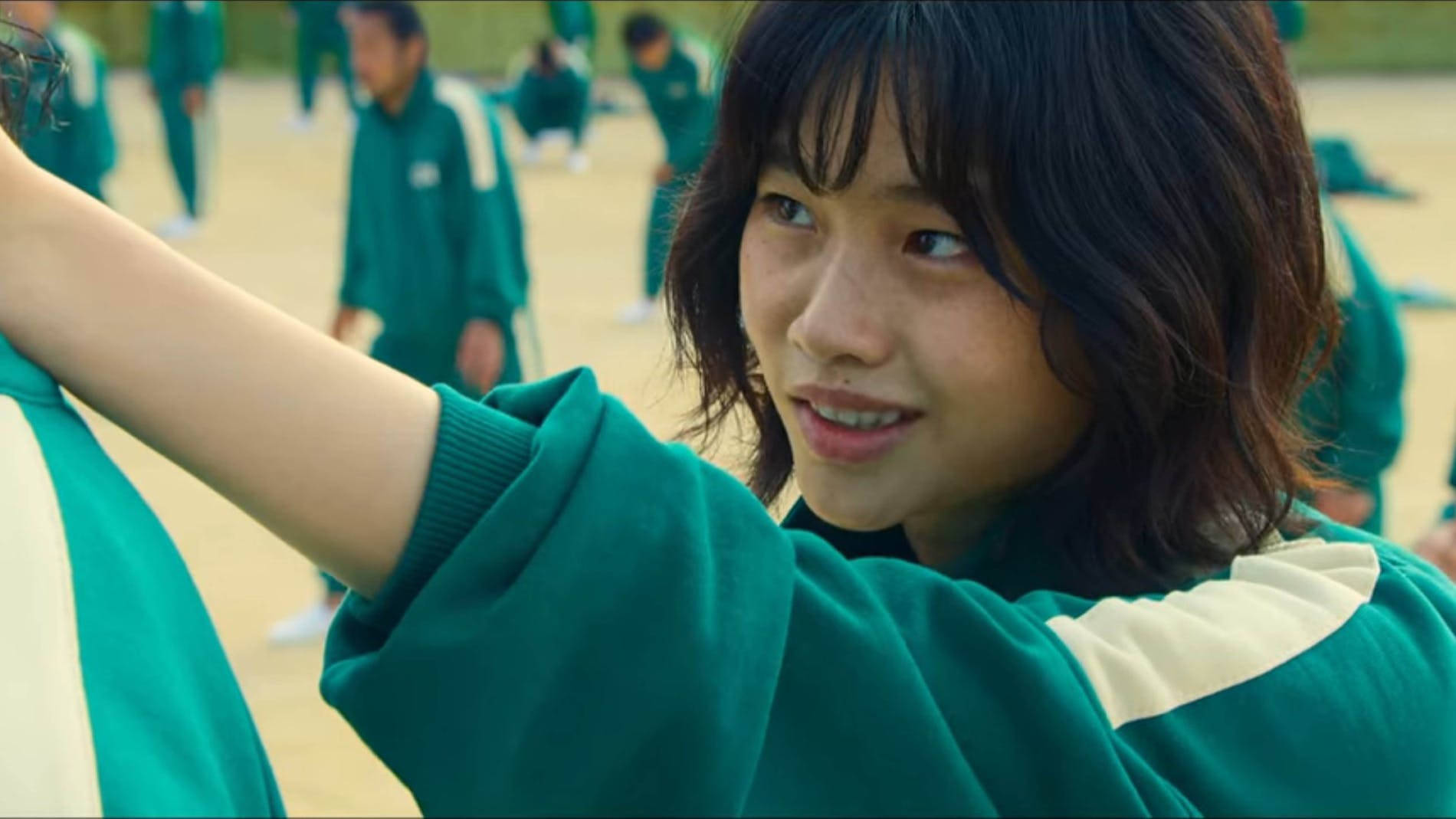 A Girl In Green Uniform Is Putting Her Head On A Girl's Shoulder Wallpaper