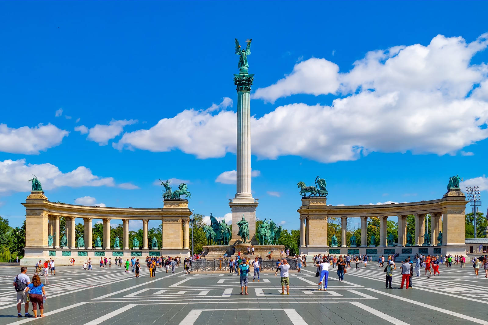 A Large Square With People Walking Around A Monument Wallpaper