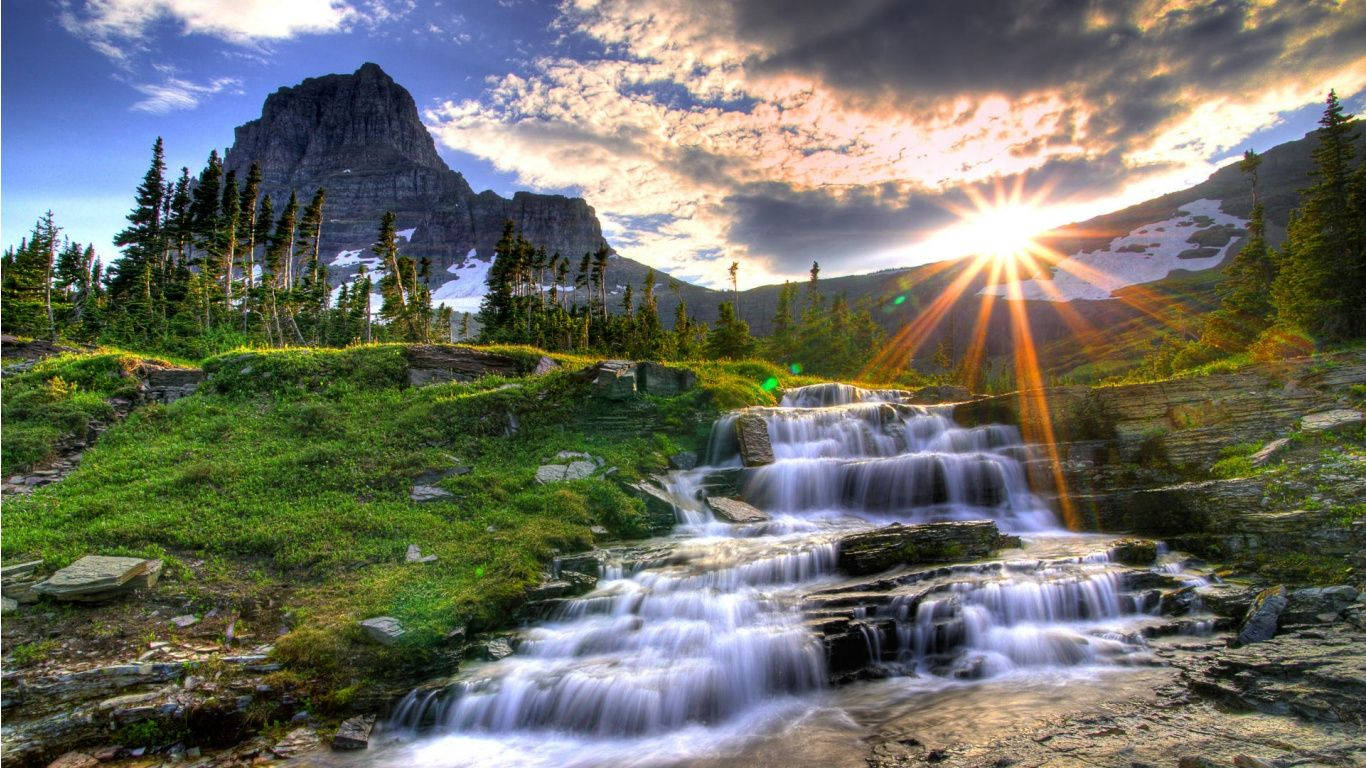 A Lush And Peaceful Mountain Stream With Cascading Water. Wallpaper