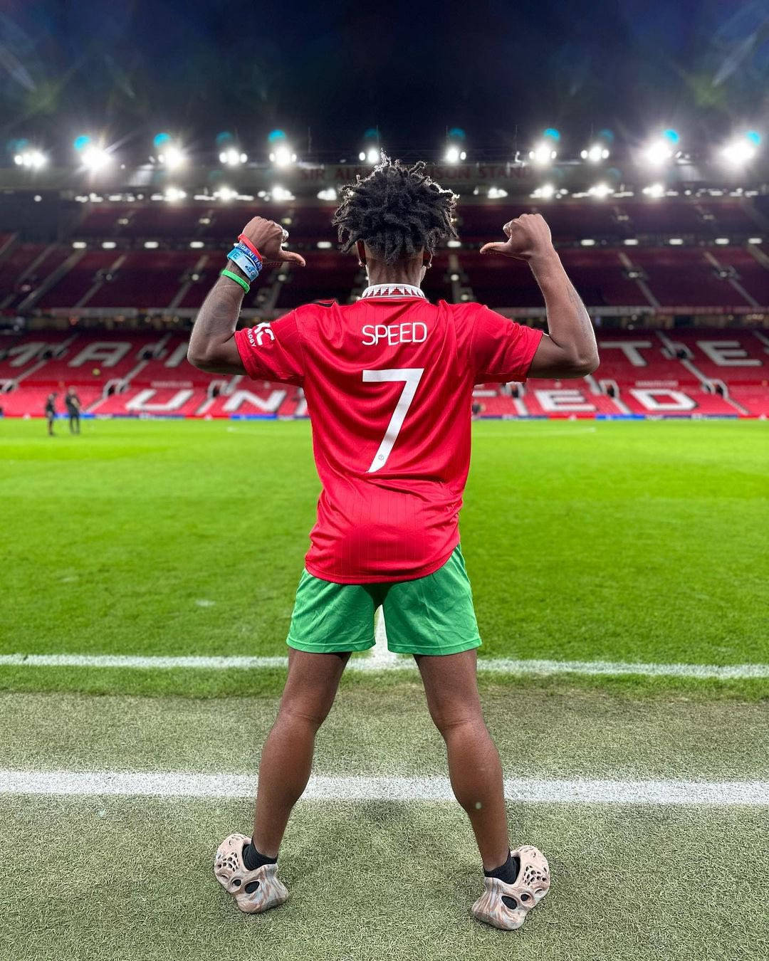 A Man In A Red Shirt Standing On A Soccer Field Wallpaper