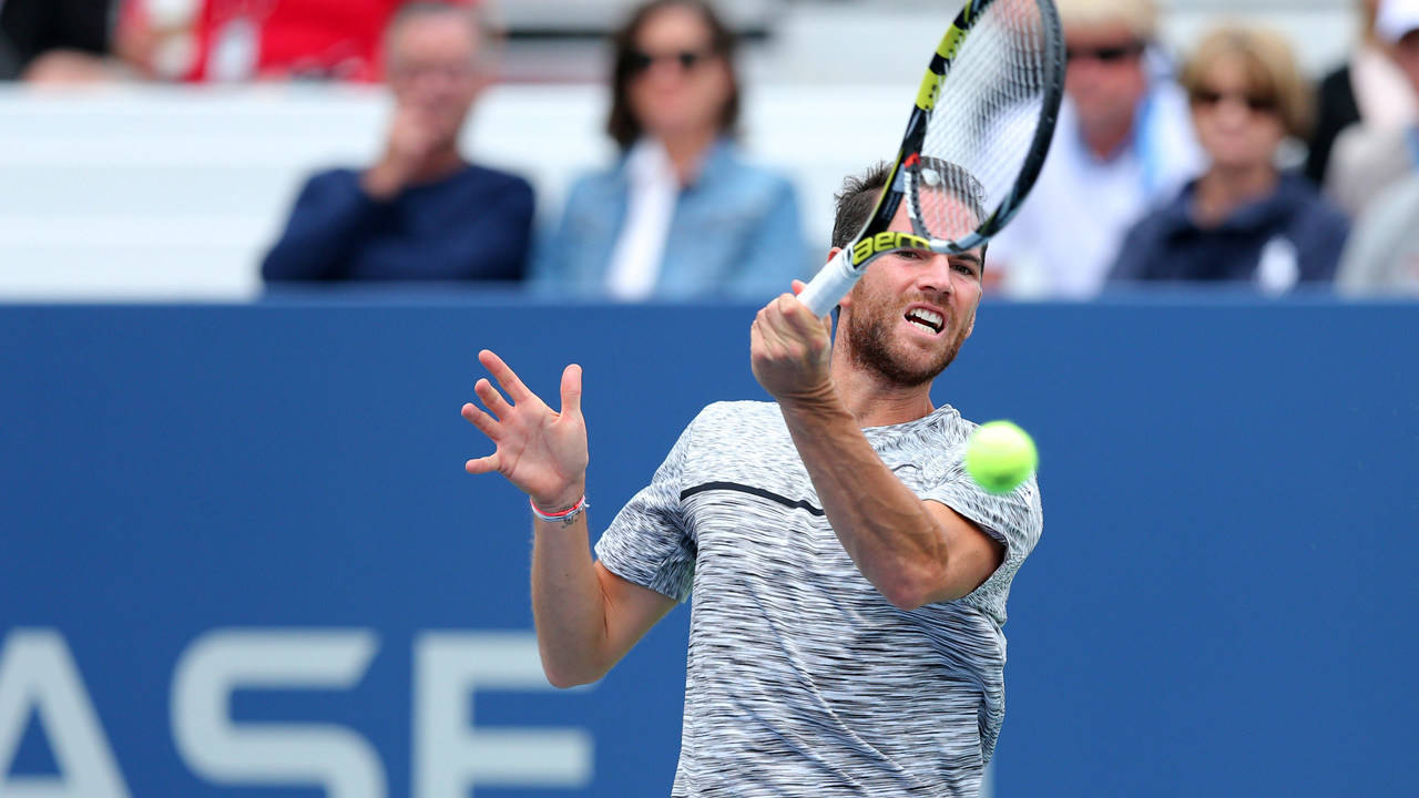 A Man Is Hitting A Tennis Ball Wallpaper