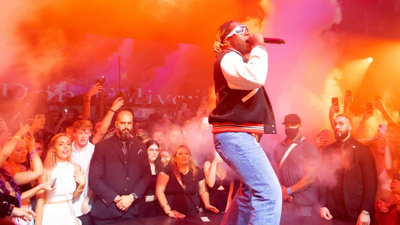 A Man Is Standing On Stage With Smoke Coming Out Of His Mouth Wallpaper