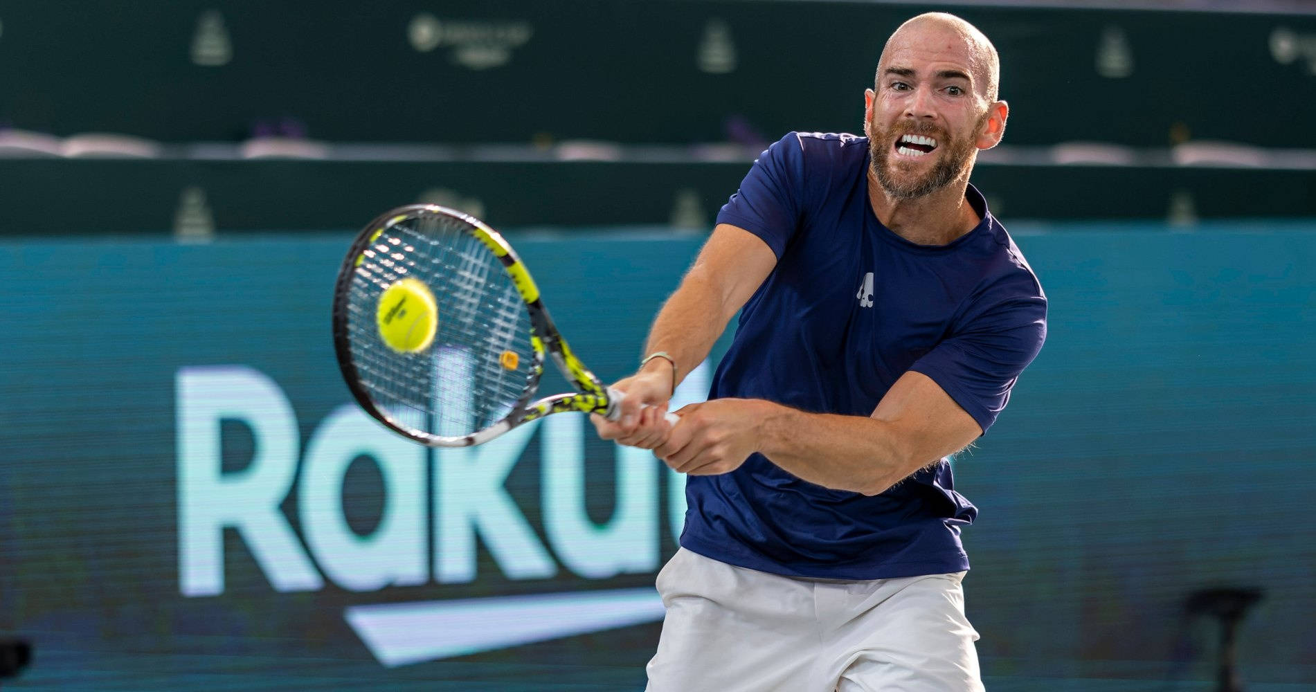 A Man Is Swinging A Tennis Racket Wallpaper