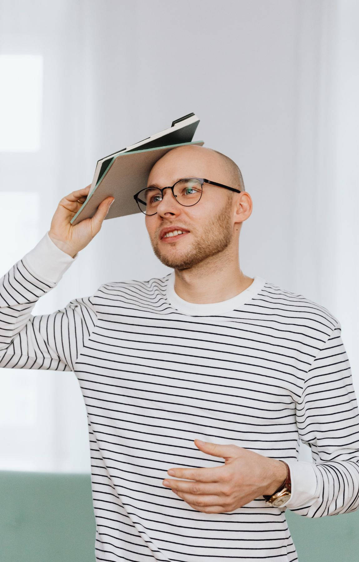 A Mature Bald Man Deeply Engrossed In Reading A Stack Of Books Wallpaper