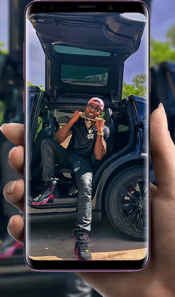 A Person Holding A Phone With A Picture Of A Car Wallpaper