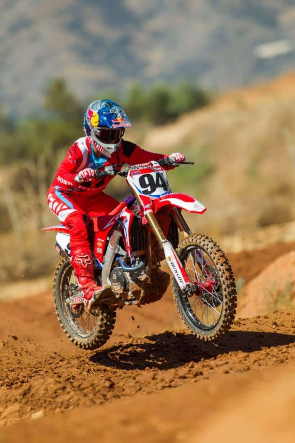 A Person Riding A Red Dirt Bike On A Dirt Track Wallpaper