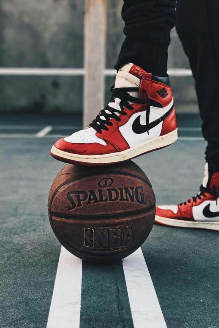 A Person Standing On A Basketball Court With A Pair Of Air Jordans Wallpaper