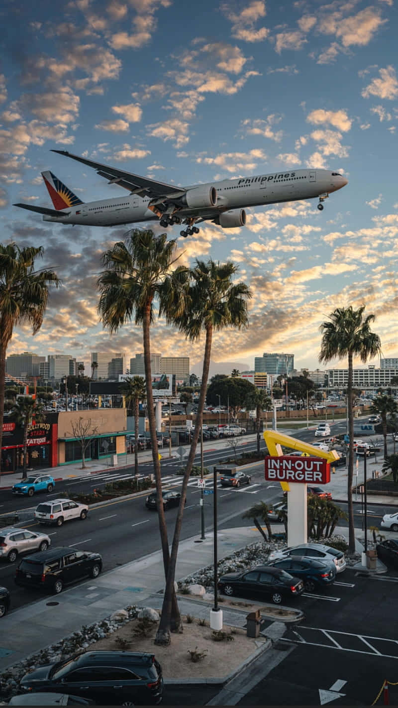 A Plane Flying Over A City Wallpaper