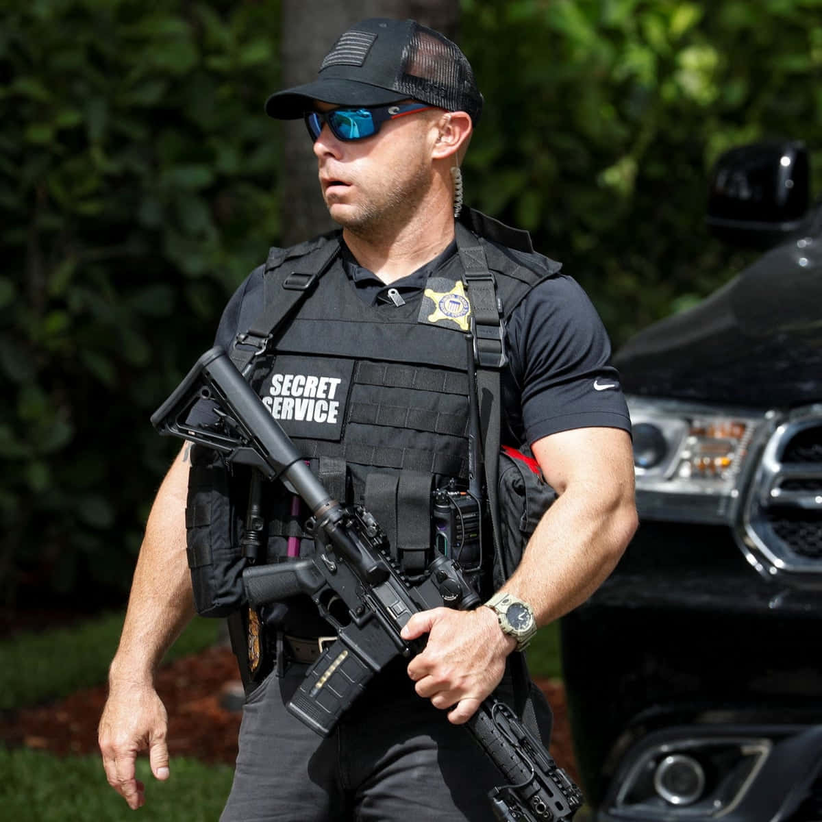 A Police Officer With A Gun Walking Down The Street Wallpaper