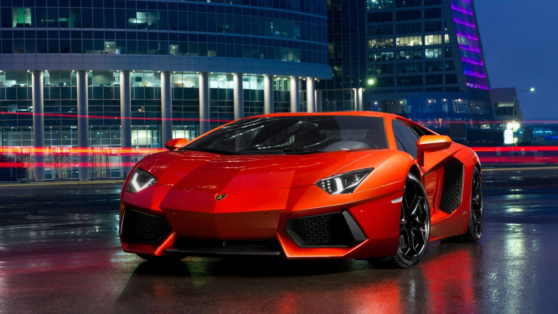 A Red Sports Car Is Parked In Front Of A Building Wallpaper