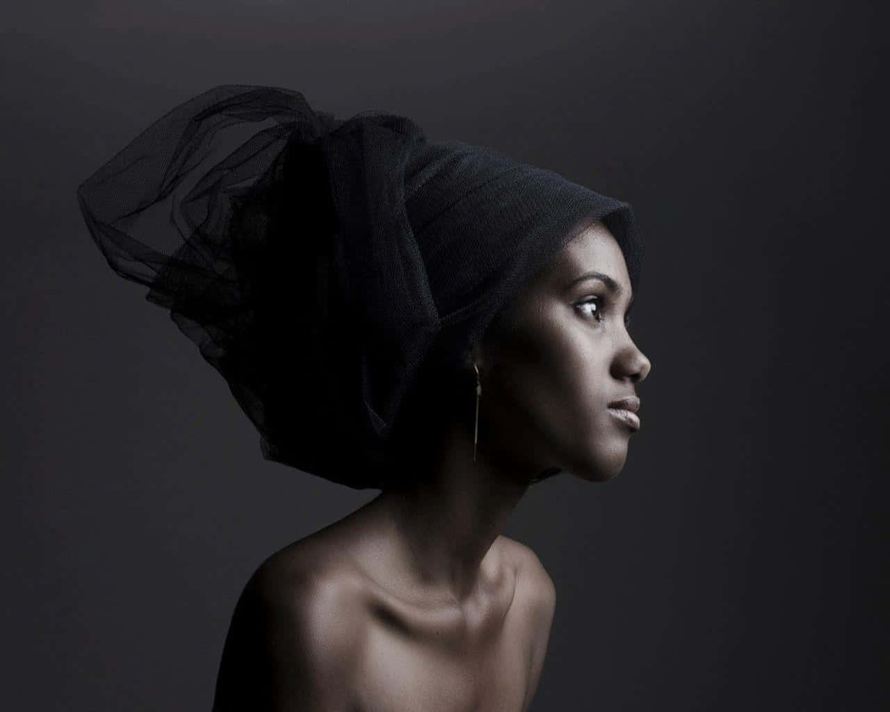 A South African Woman In Traditional Black Head Wrap Exhibiting Cultural Pride Wallpaper