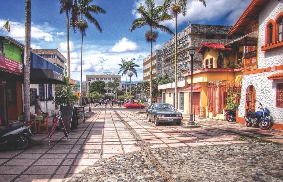 A Street With Palm Trees And Buildings Wallpaper