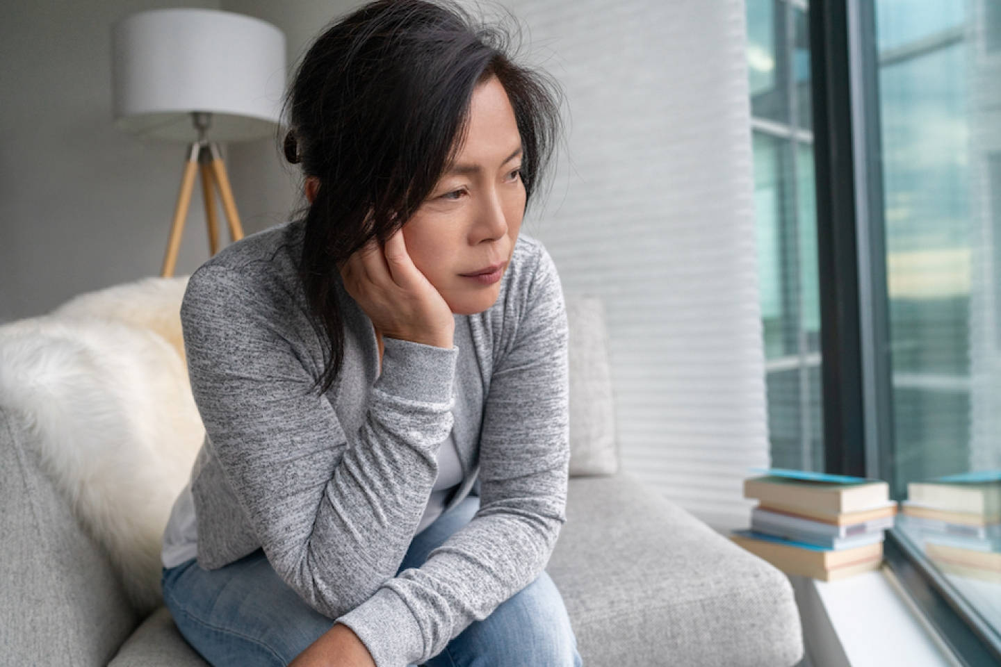 A Stressed Woman Sitting Anxiously On A Couch Wallpaper