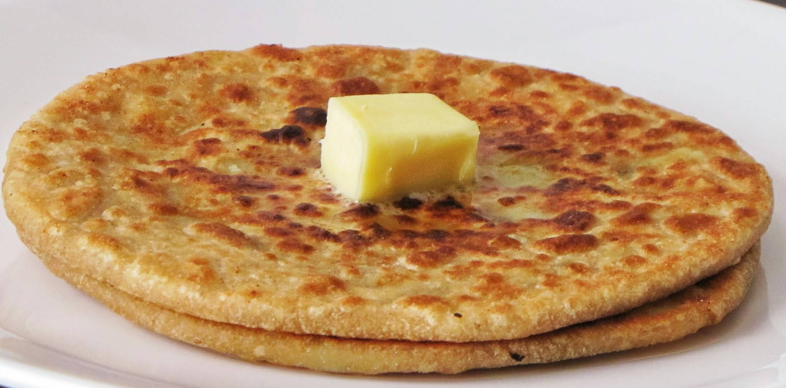 A Tempting Slice Of Flatbread Generously Spread With Butter Wallpaper