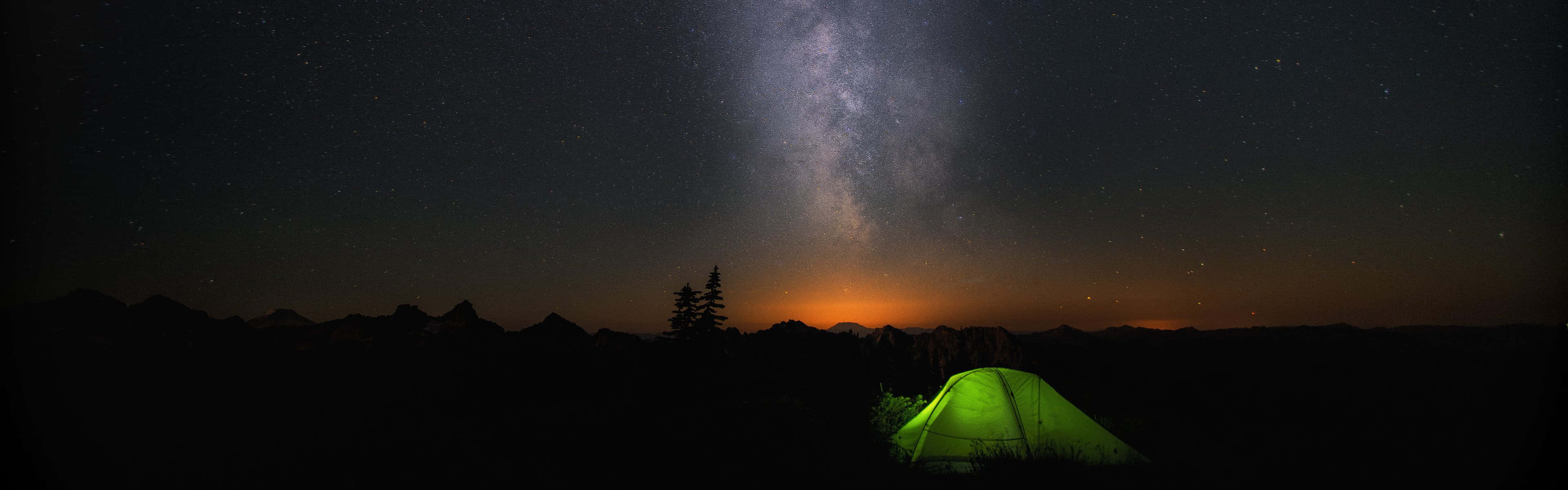 A Tent Is Lit Up Under The Milky Wallpaper