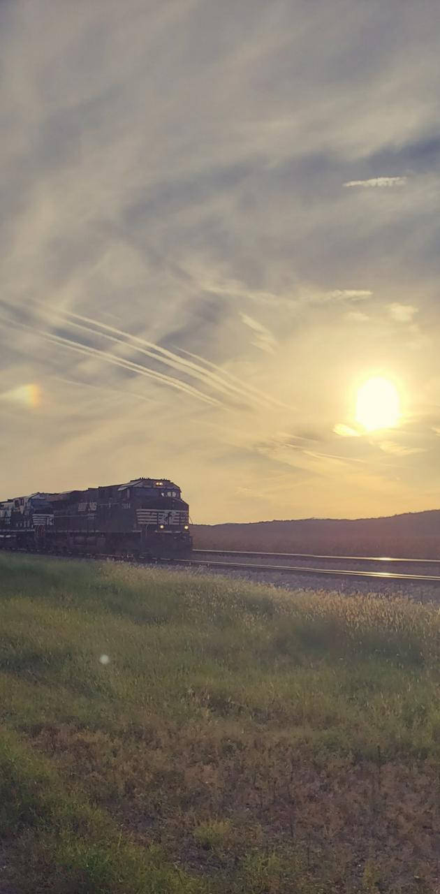 A Train Passing Along Norfolk's Countryside In Virginia Wallpaper