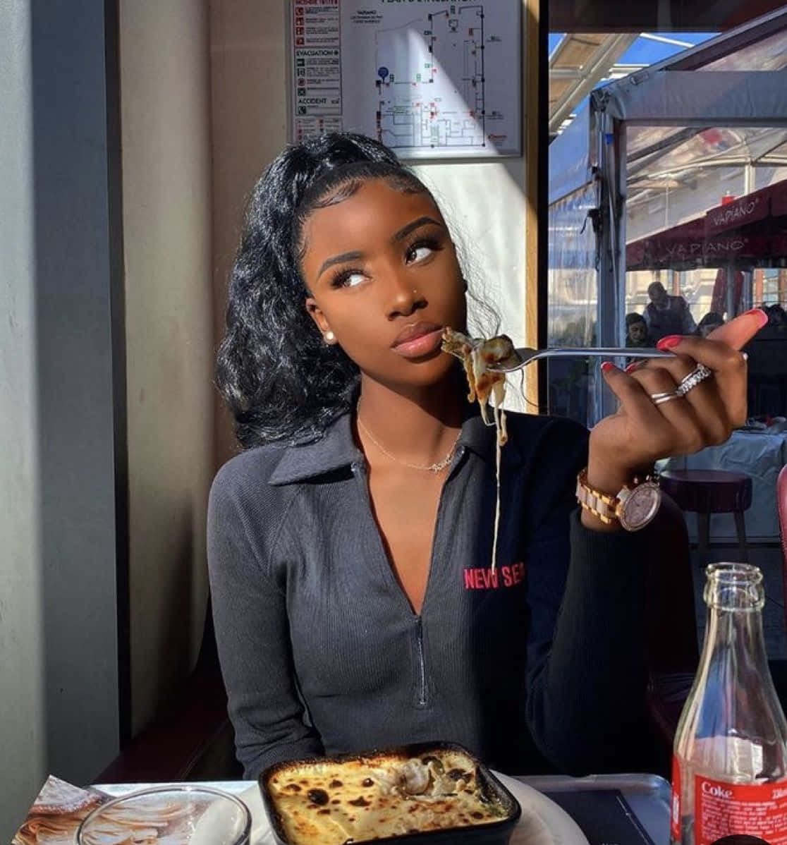 A Woman Eating A Pizza In A Restaurant Wallpaper