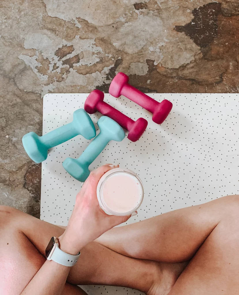 A Woman Holding A Cup Of Coffee And Dumbbells Wallpaper