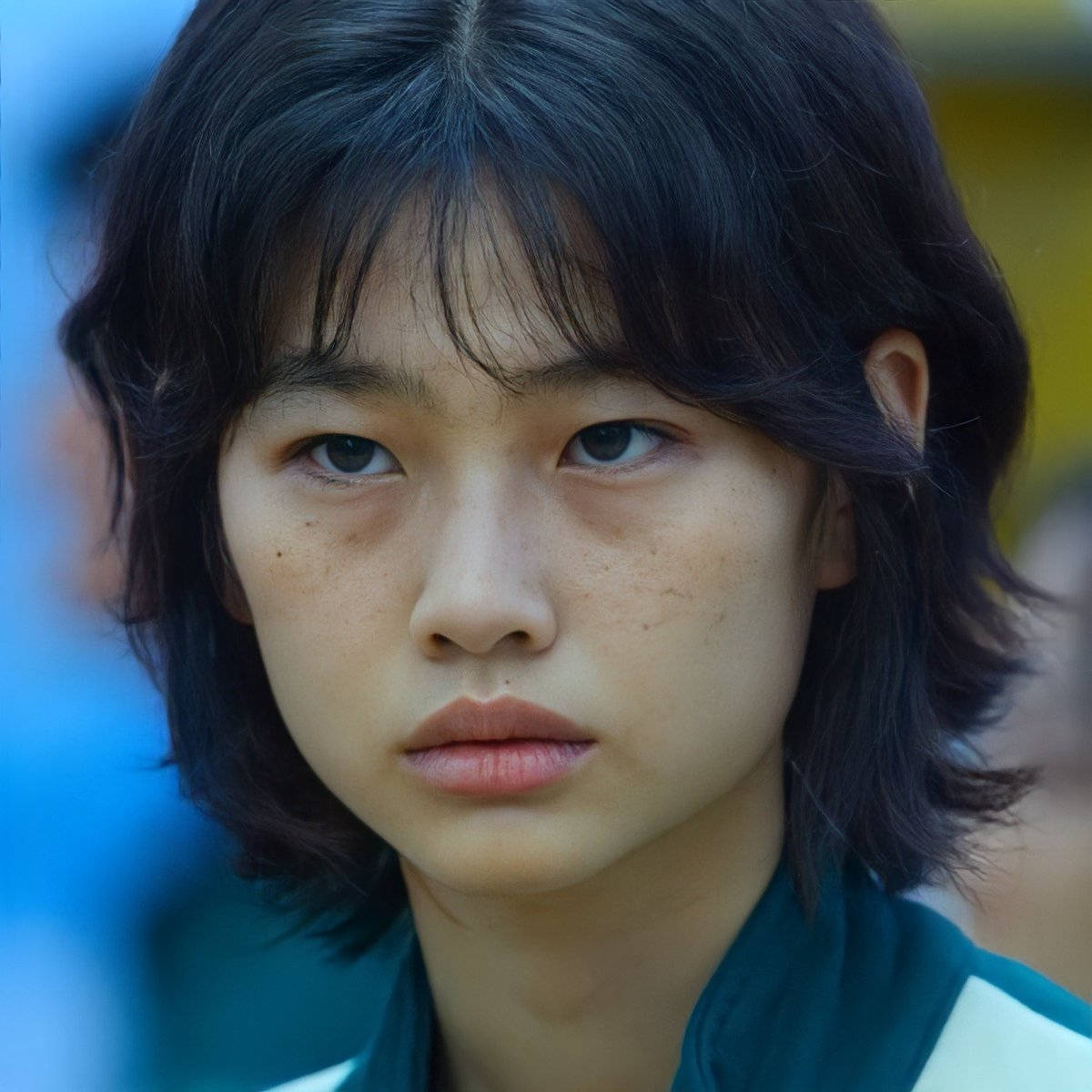 A Young Asian Girl With Dark Hair And A Green Jacket Wallpaper