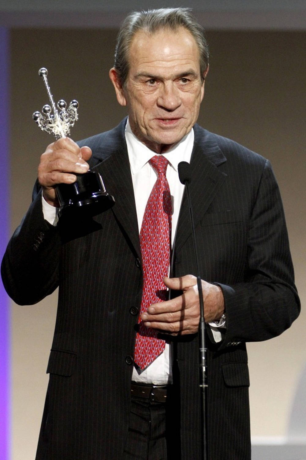 Acclaimed Actor Tommy Lee Jones Grasping A Trophy Wallpaper