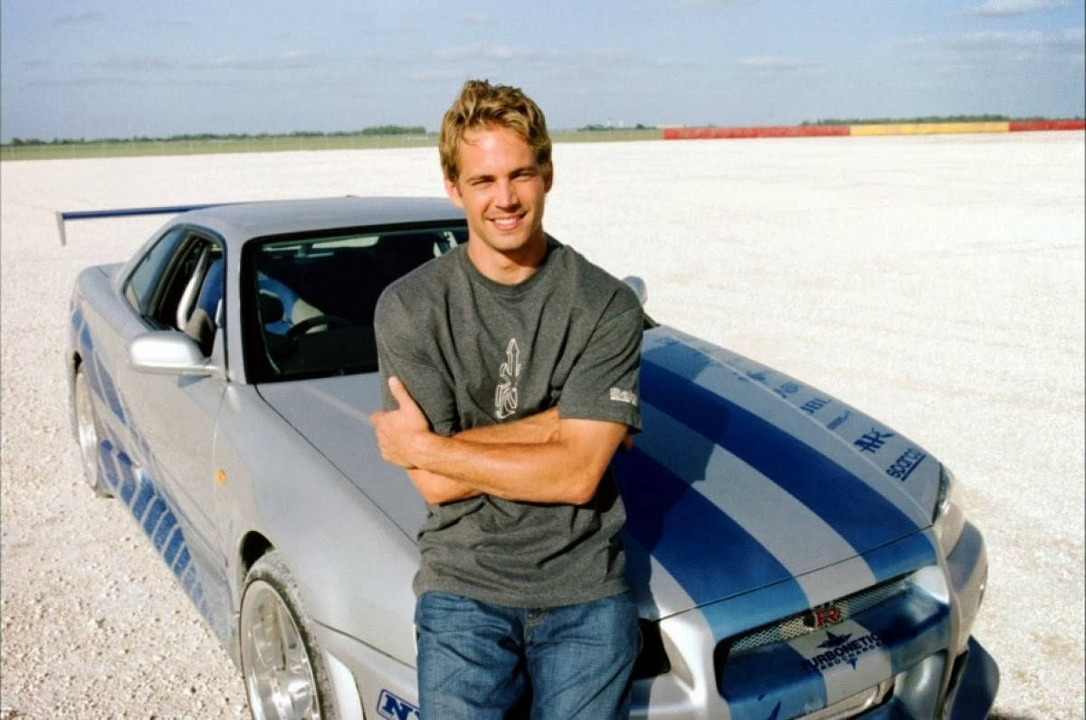 Actor Paul Walker In Front Of His Iconic Porsche Lykan Supercar. Wallpaper