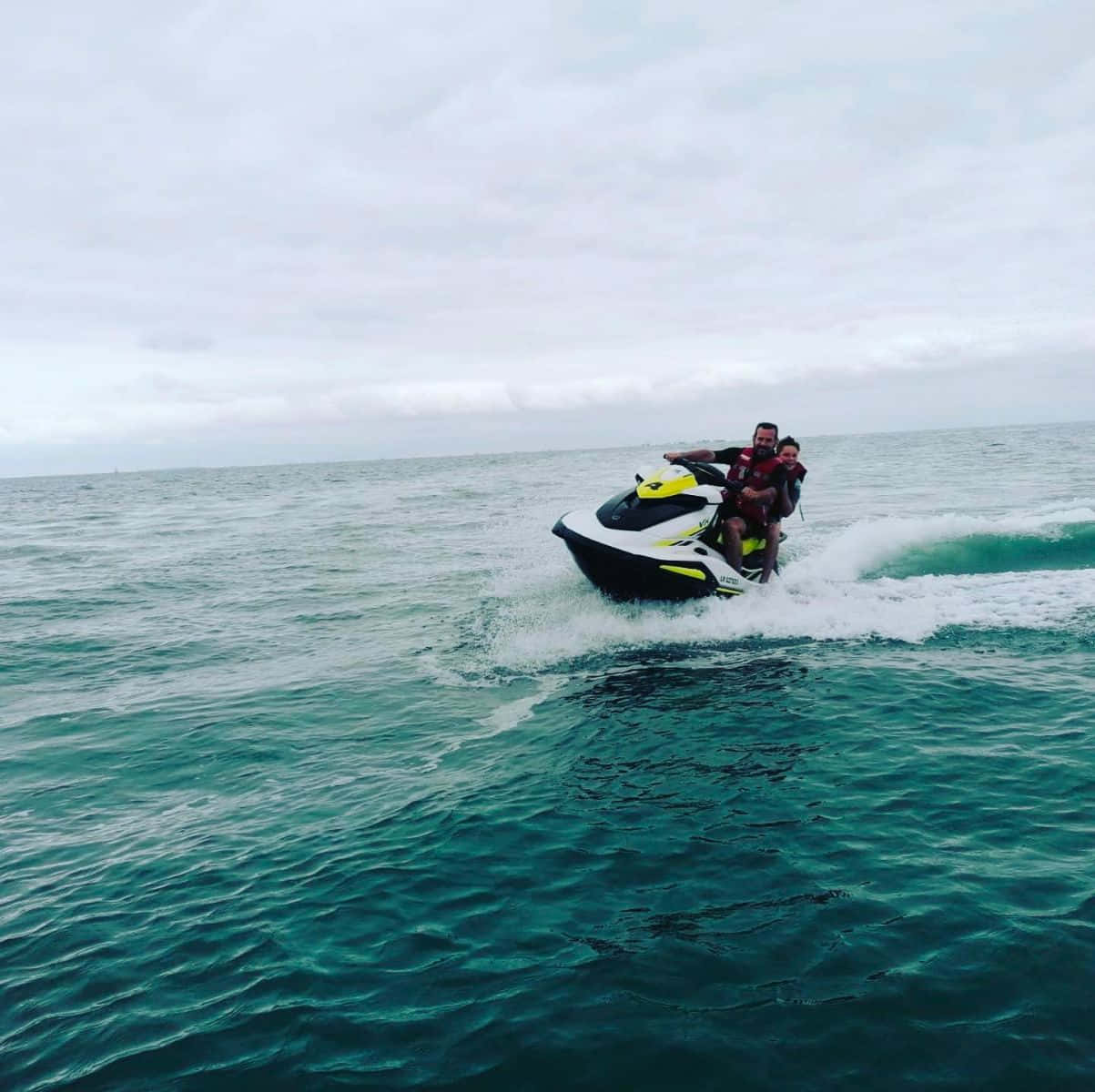 Adventurous Couple Enjoying A Jet Ski Ride Wallpaper