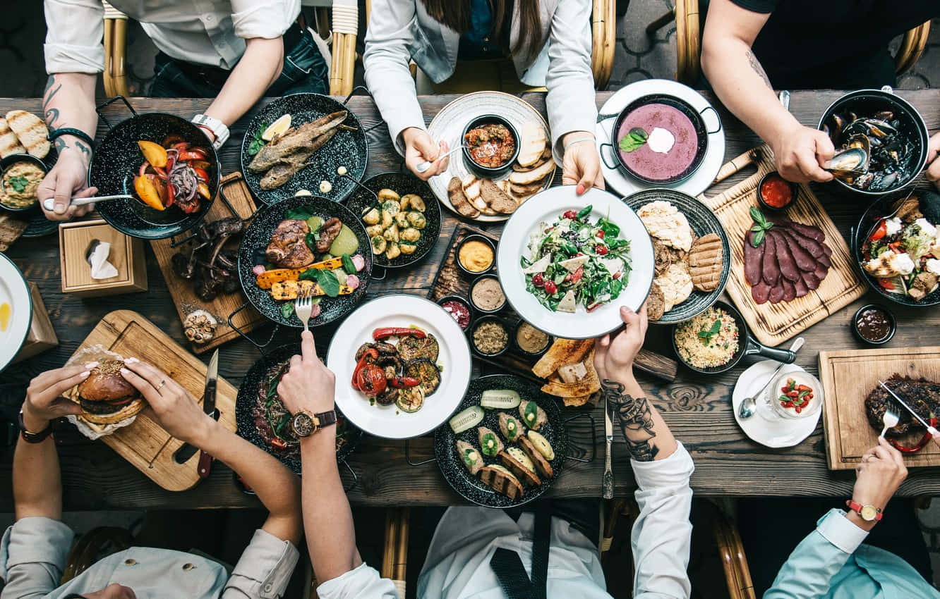 An Array Of Delicious Dishes On A Beautifully Set Dining Table Wallpaper