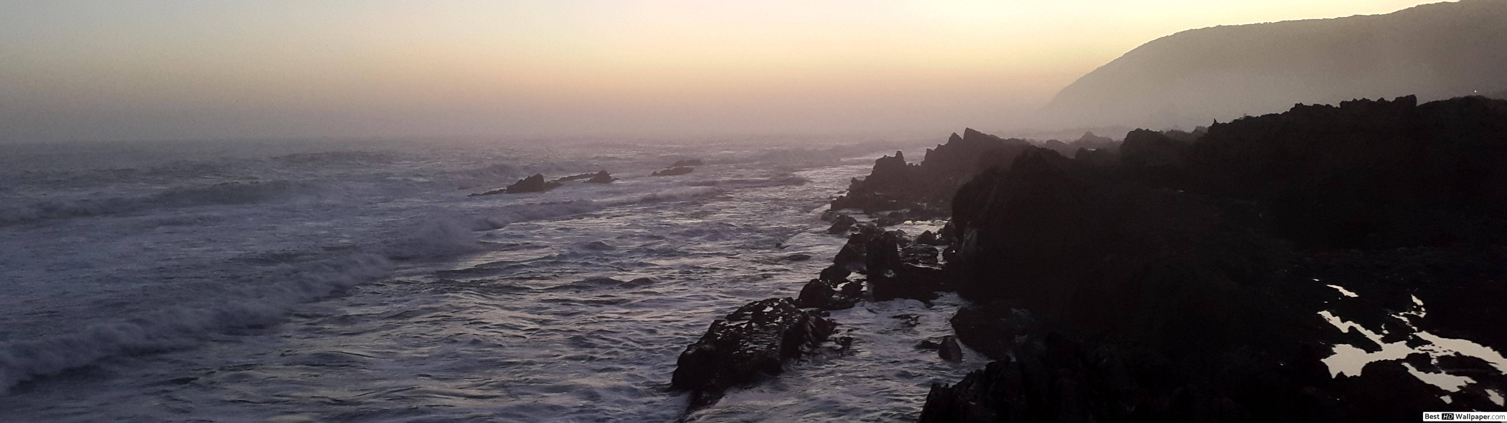 Back-lit Rocky Cliff Litters The Horizon Wallpaper