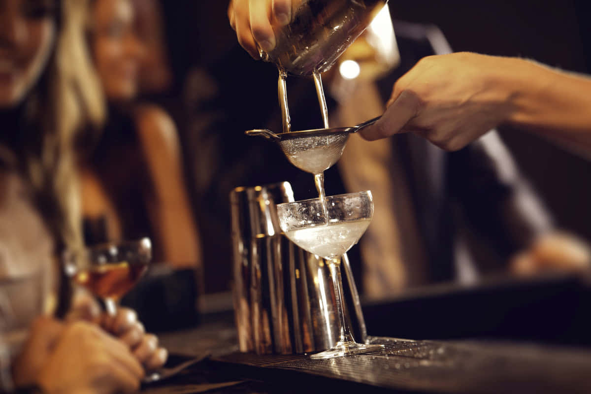 Bartender Pouring Cocktailat Bar Wallpaper