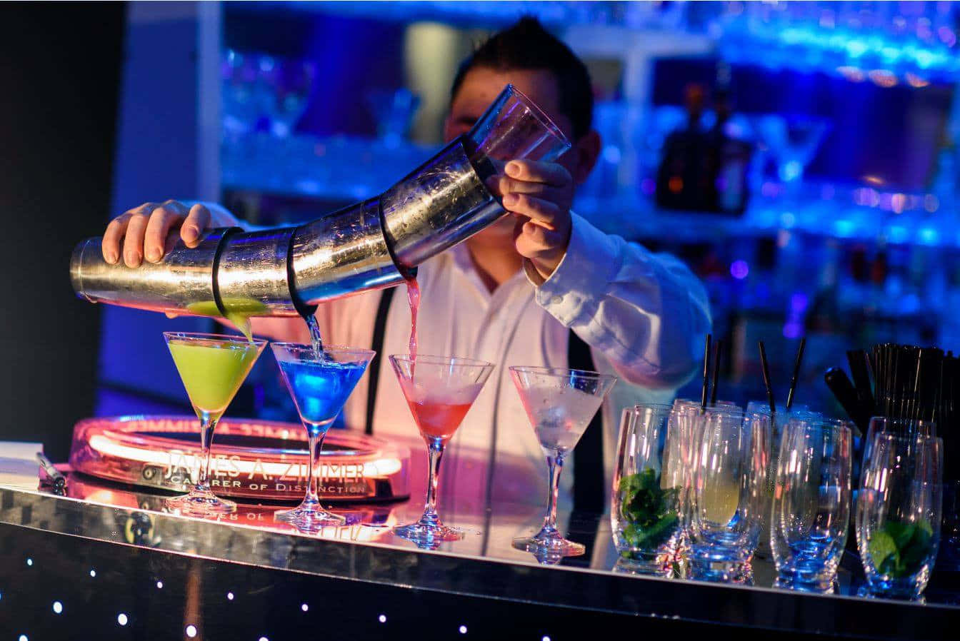 Bartender Pouring Cocktailsat Bar Wallpaper