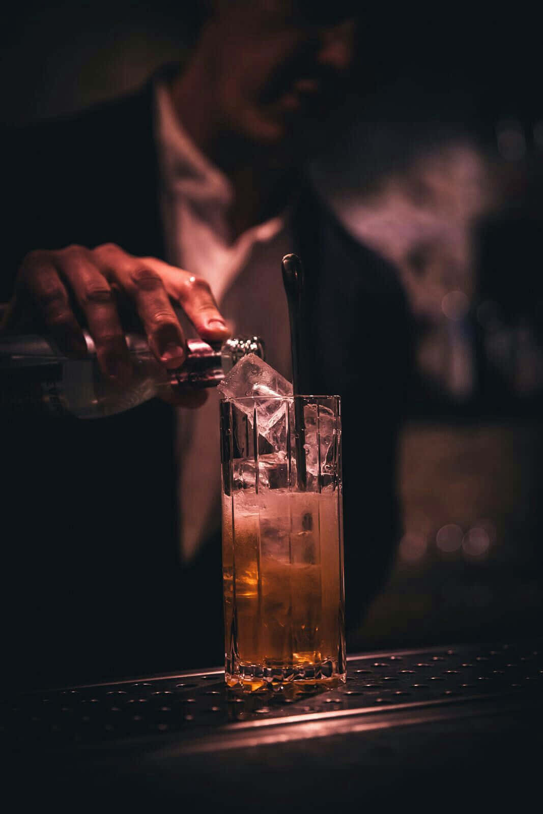 Bartender Pouring Drinkat Bar Wallpaper