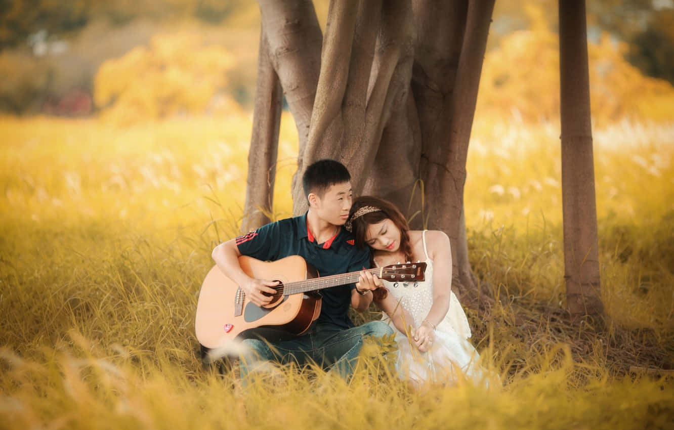 Boyfriend Playing Guitar For His Girlfriend Wallpaper