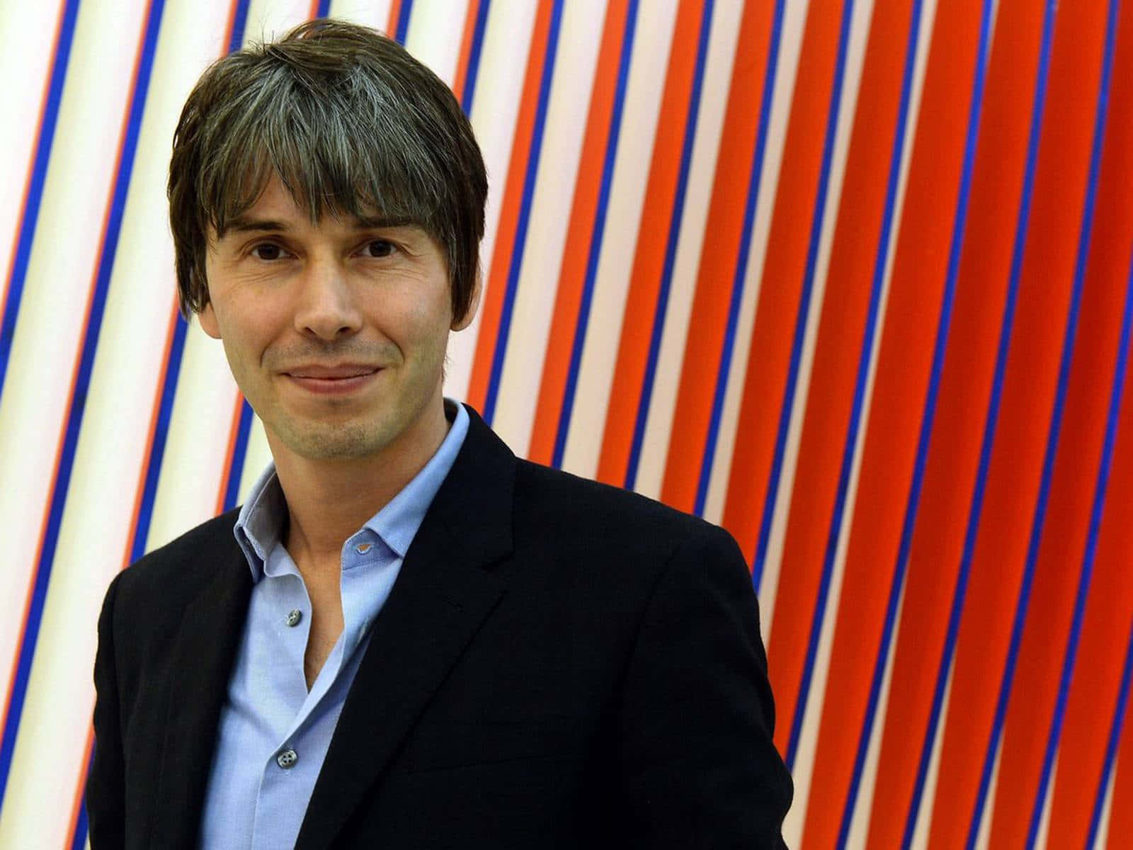 Brian Cox Smiling Against Striped Background Wallpaper