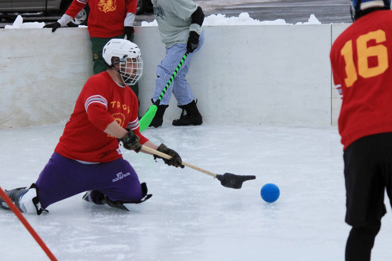 Broomball Player In Action From Red Team. Wallpaper