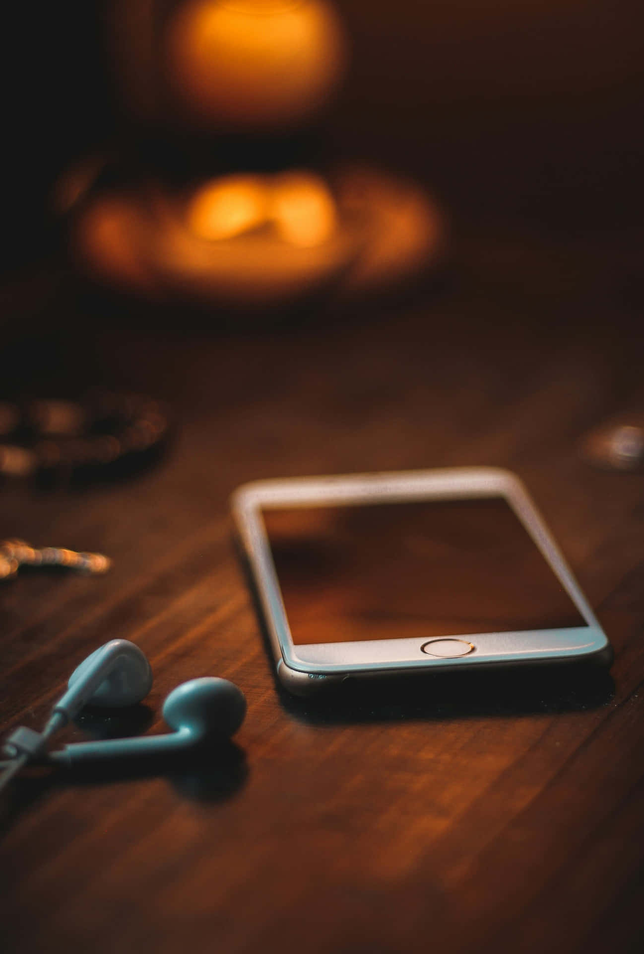 Candlelit Smartphoneand Earphones Wallpaper