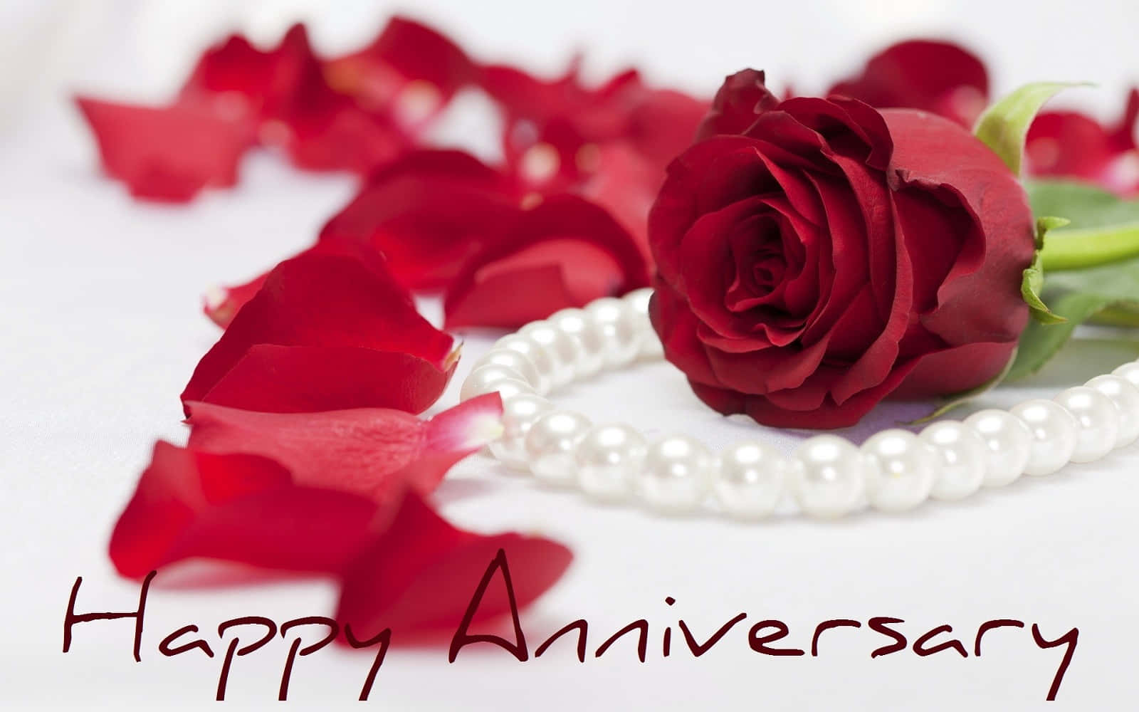 Caption: Elegant Pearl Necklace Adorning A Red Rose On A Romantic Anniversary Wallpaper