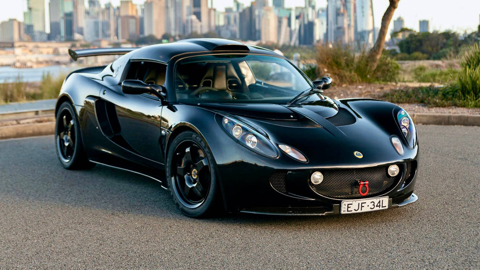 Caption: Striking Black Lotus Exige Dominating The Road Wallpaper