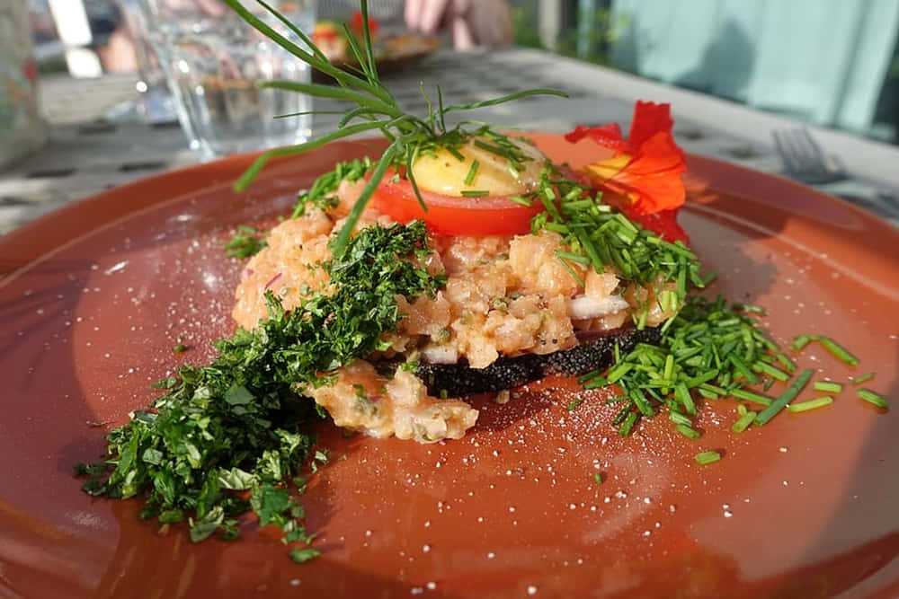 Caption: Tasty Ground Salmon Dish Garnished With Chives On An Orange Plate Wallpaper