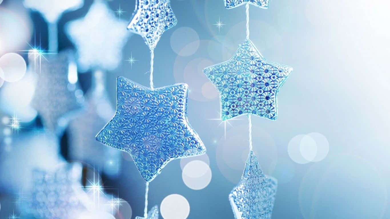 Christmas Star Decorations Hanging From A Blue Background Wallpaper