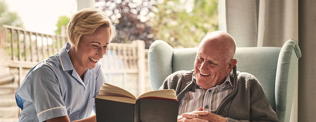 Compassionate Caretaker Assisting Elderly Patient Wallpaper