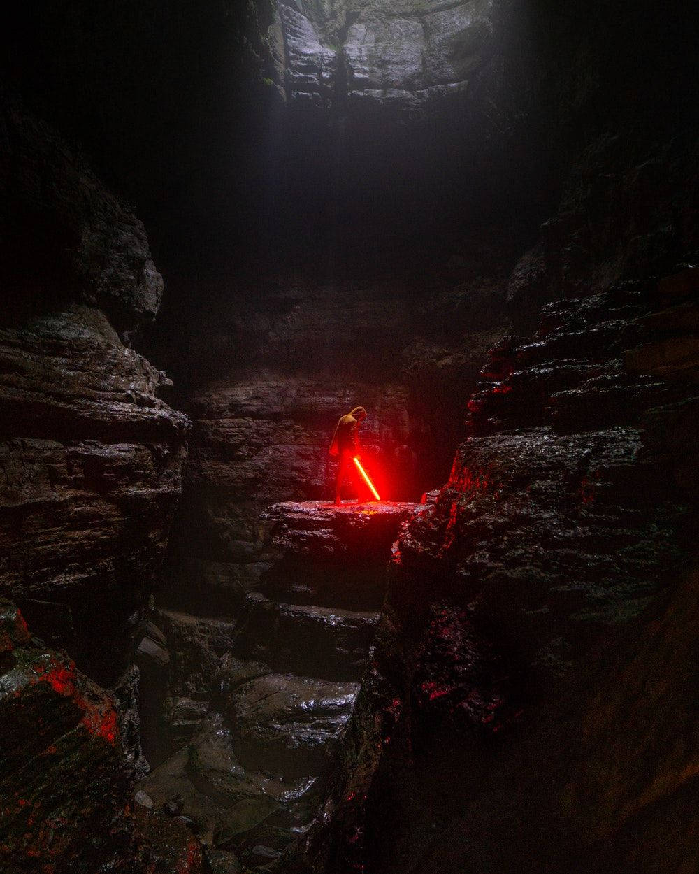 Cool Men Red Aesthetic Lightsaber In Cave Wallpaper