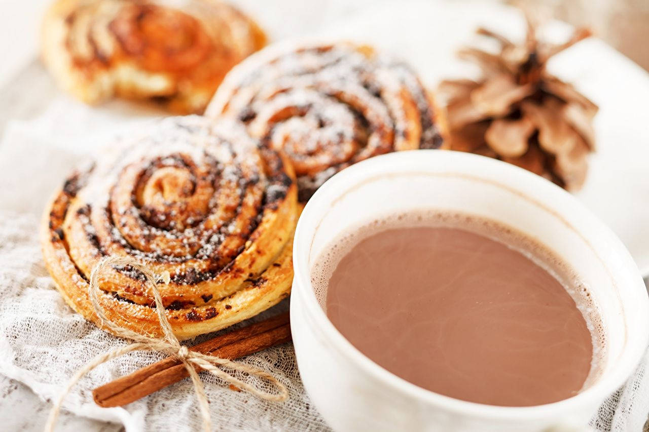 Cozy Ambience With Cinnamon Rolls And Hot Chocolate Wallpaper