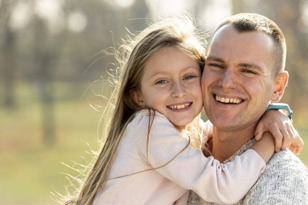 Dad Smiling Happily With Daughter Wallpaper