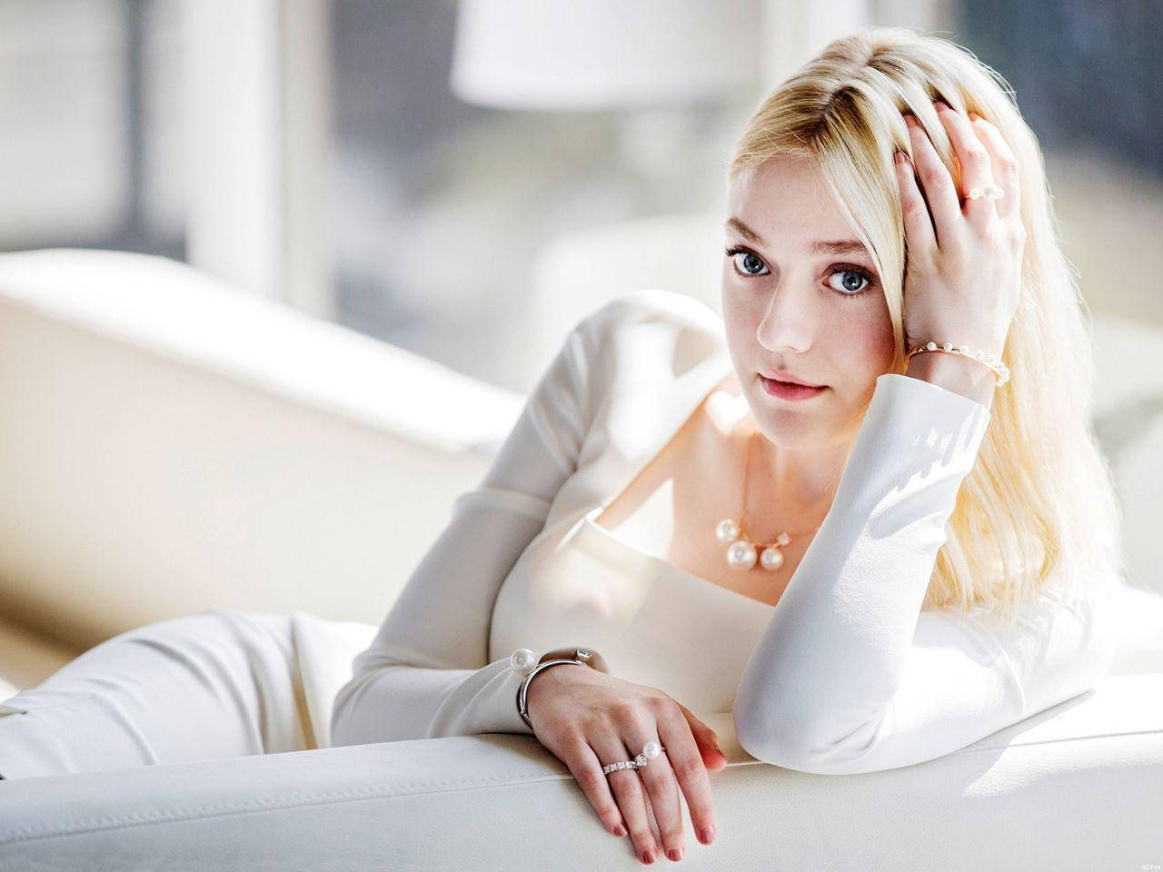 Dakota Fanning Relaxes On Couch Wallpaper